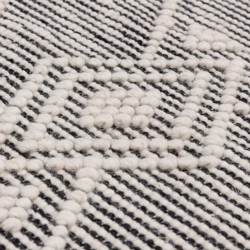 Close up of textured wool rug with black and white geometric pattern