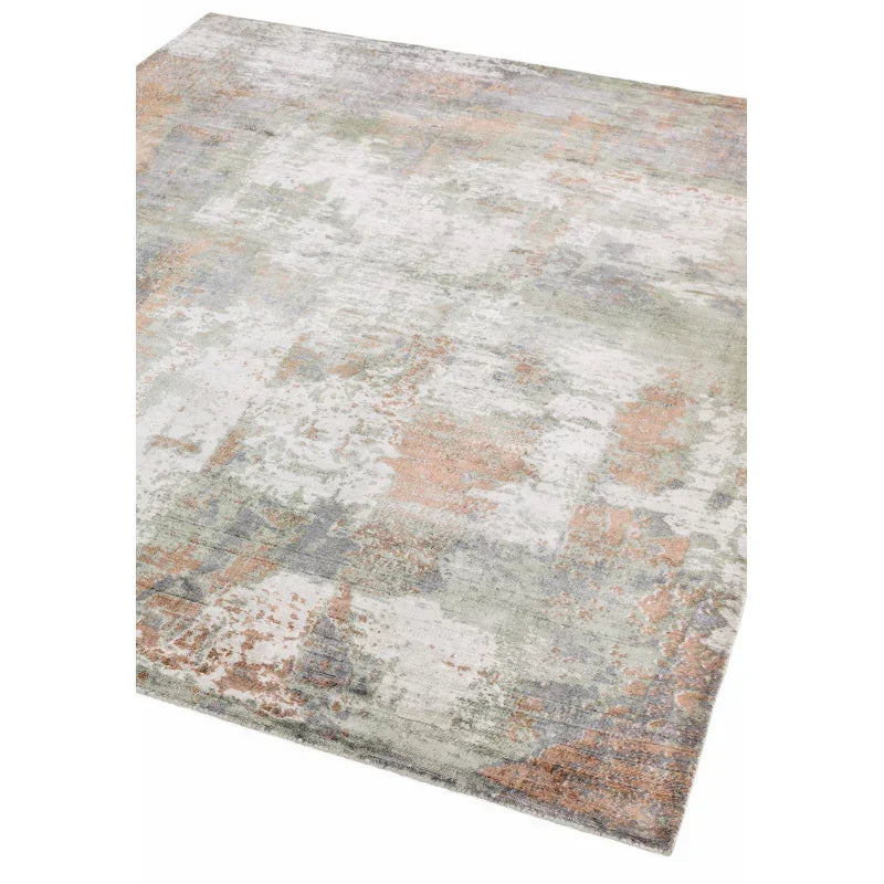 Abstract area rug with muted grey, beige, and rust pattern, corner view