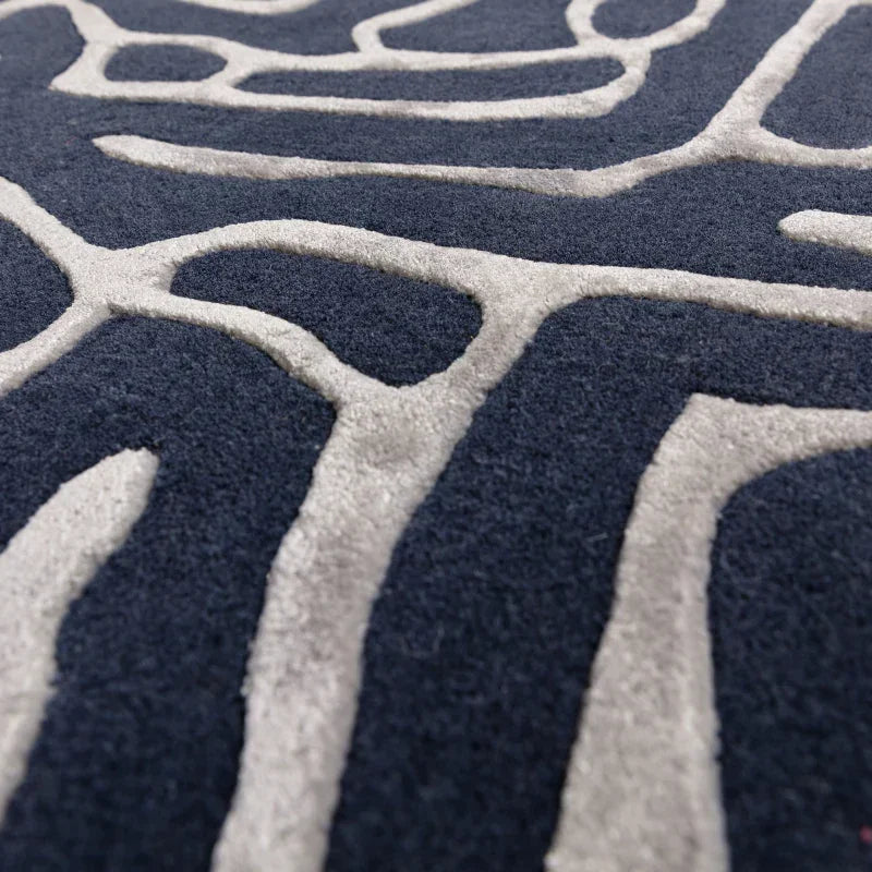 Close up of modern navy blue and grey patterned rug with raised textured lines