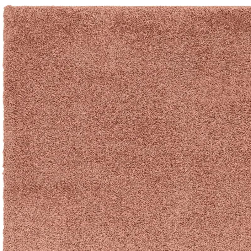 Close-up of soft pink shaggy rug texture showing corner details