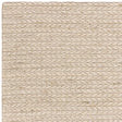 Close-up of cream woven wool rug corner showing textured braided pattern