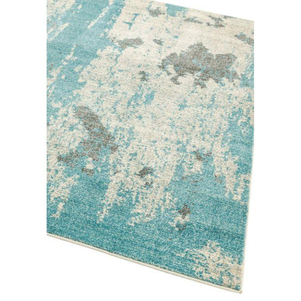 Blue and cream abstract area rug with textured pattern, angled corner view