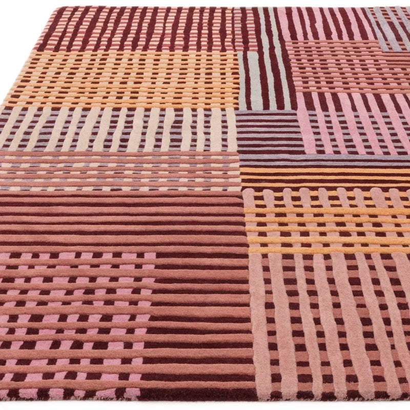Geometric patterned area rug with textured stripes in pink, burgundy, and beige tones