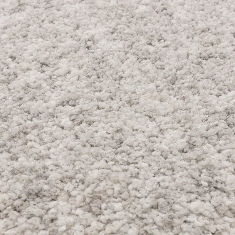 Close view of soft grey and white shaggy rug texture and pile detail