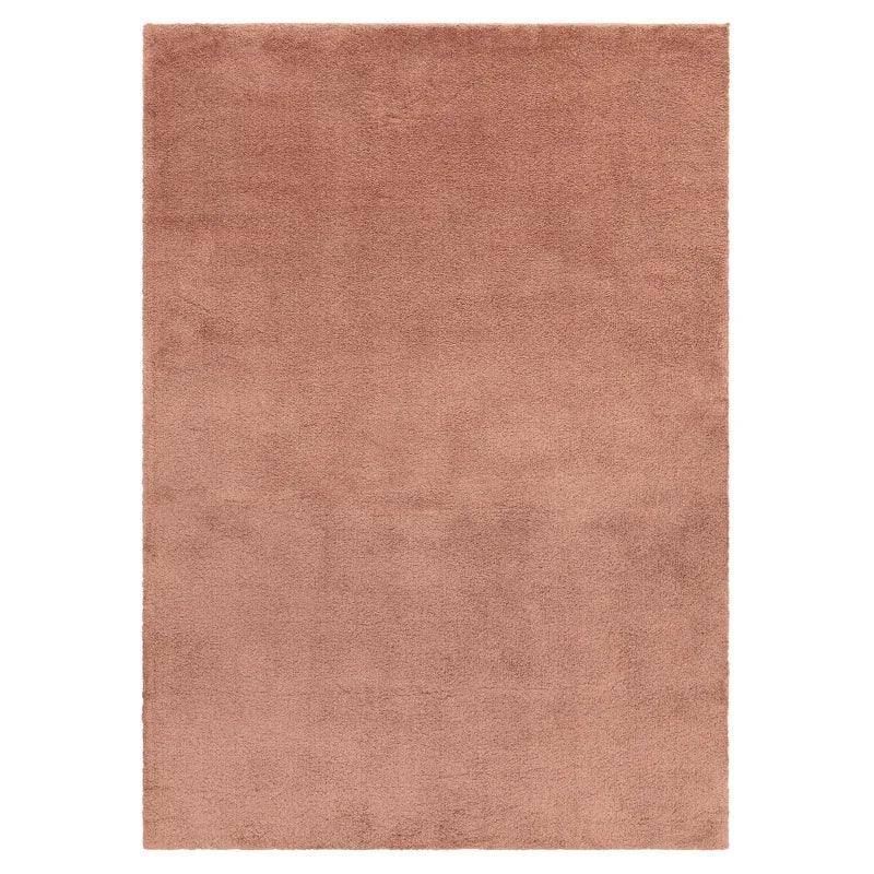 Rectangular blush pink area rug with soft, plain texture shown from above