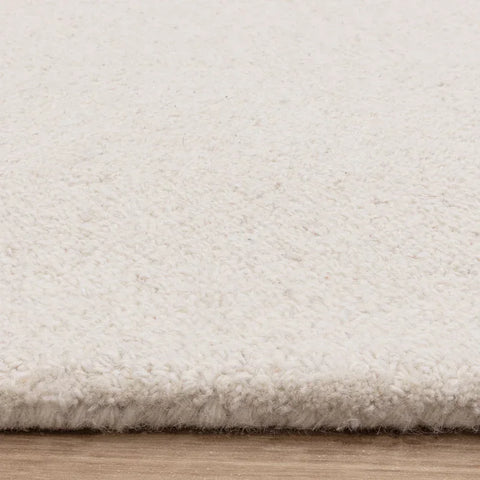 Close up of cream wool rug texture on wooden floor
