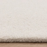 Close up of cream wool rug texture on wooden floor
