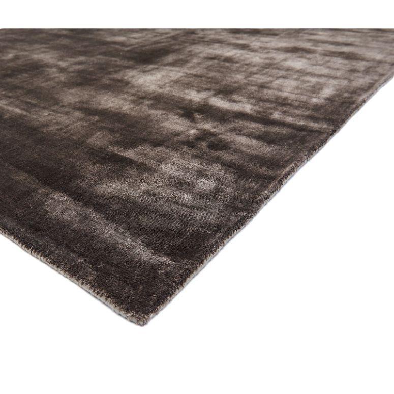 Rectangular dark brown area rug with subtle textured pattern, low pile and finished edge