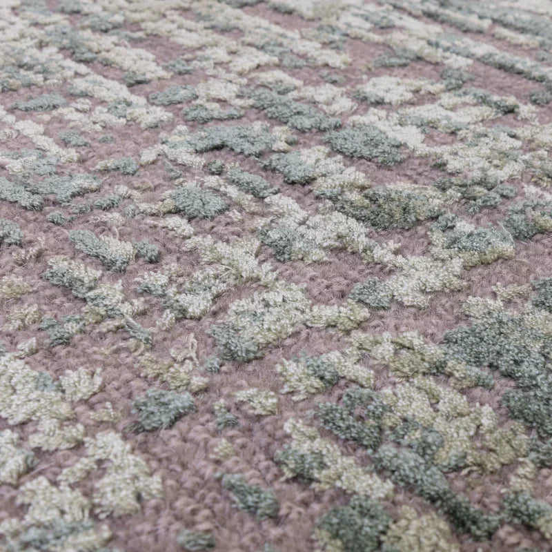Textured area rug with raised green and beige abstract pattern on taupe background