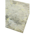 Abstract area rug with grey, beige, and yellow tones, close view of textured corner