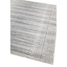 Grey patterned area rug with textured border and circular detailing, angled corner view
