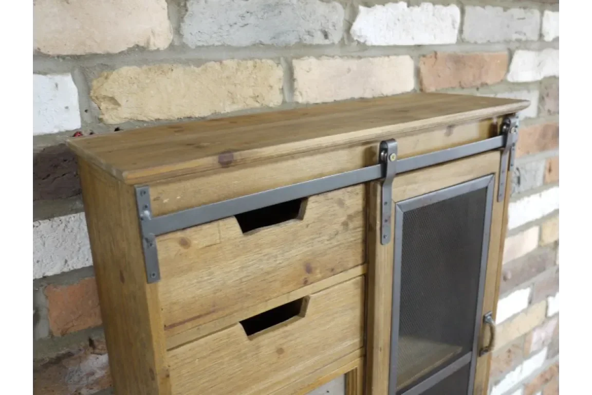 Rustic wooden sideboard with metal sliding door and drawers against brick wall