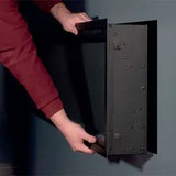 A person installing the Atmos electric fire into a wall.