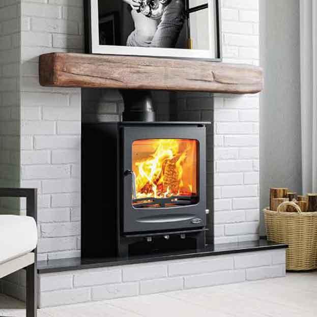 Black wood burning stove in white brick fireplace with wooden mantel and firewood basket