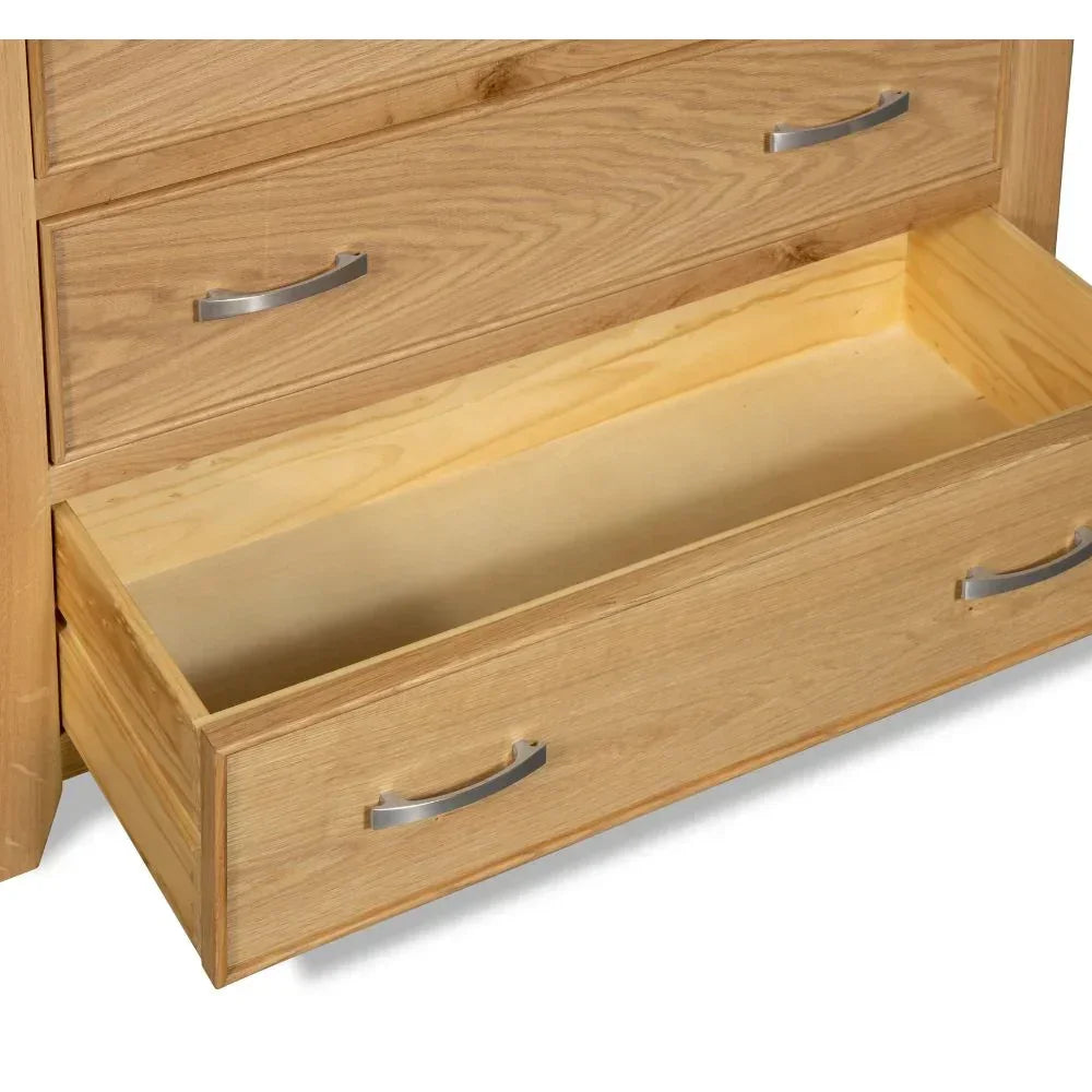 Oak chest of drawers with bottom drawer open, showcasing metal handles and wood grain