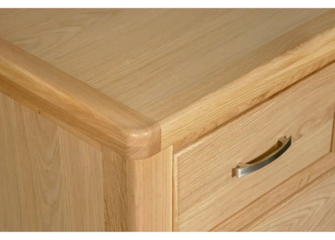 Light oak chest of drawers corner with silver handle and smooth wood grain finish