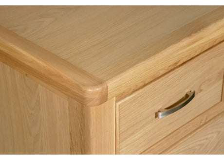 Light oak chest of drawers corner with silver handle and smooth wood grain finish