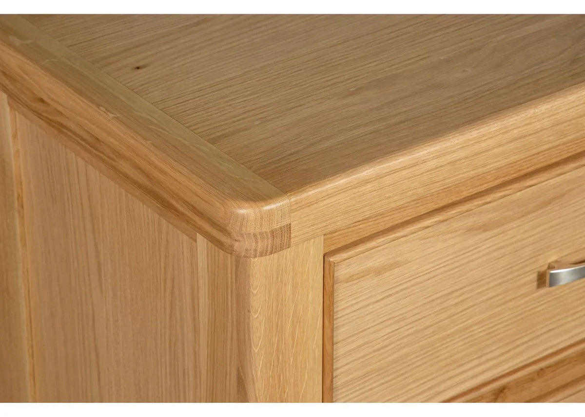 Oak chest of drawers corner detail showing smooth finish and metal handle
