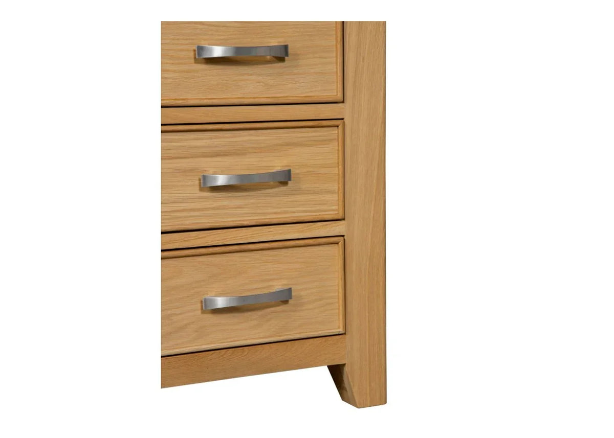 Oak bedside table bottom with metal handles and wood grain finish, close-up of drawers
