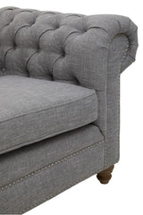 Three-seat sofa upholstered in grey linen with a tufted backrest and rolled armrest, featuring wooden legs