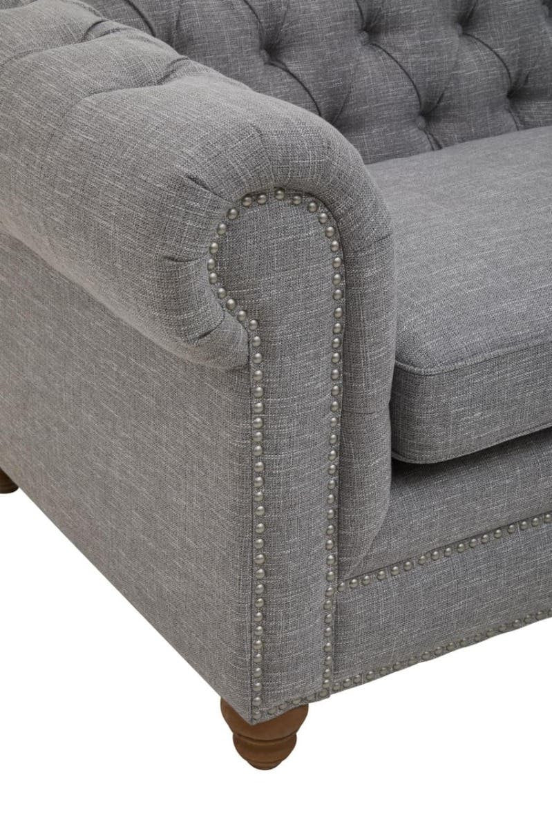 Grey linen sofa featuring a tufted backrest, rolled arms, and wooden legs. The fabric has a soft texture, and the overall design is elegant and modern, suitable for various interior styles