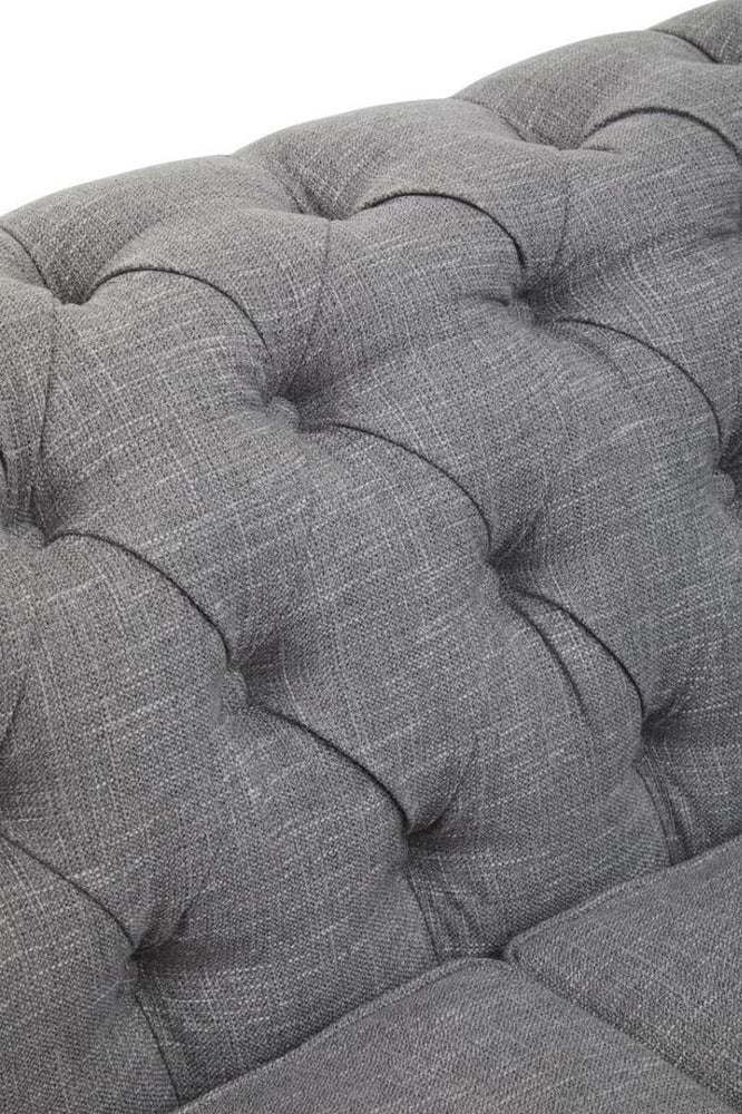 Close-up view of the tufted grey linen upholstery on the Stella three-seat sofa, showcasing the soft texture and button detailing