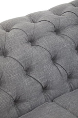 Close-up view of the tufted grey linen upholstery on the Stella three-seat sofa, showcasing the soft texture and button detailing