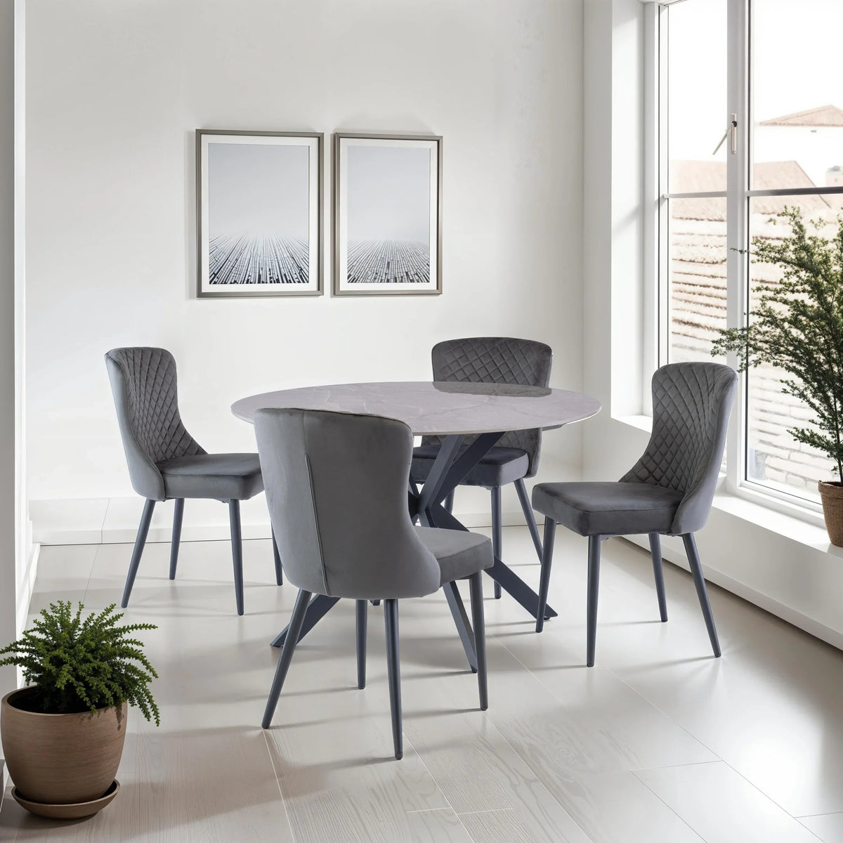 Grey velvet dining chairs with quilted backs and round marble dining table in modern room