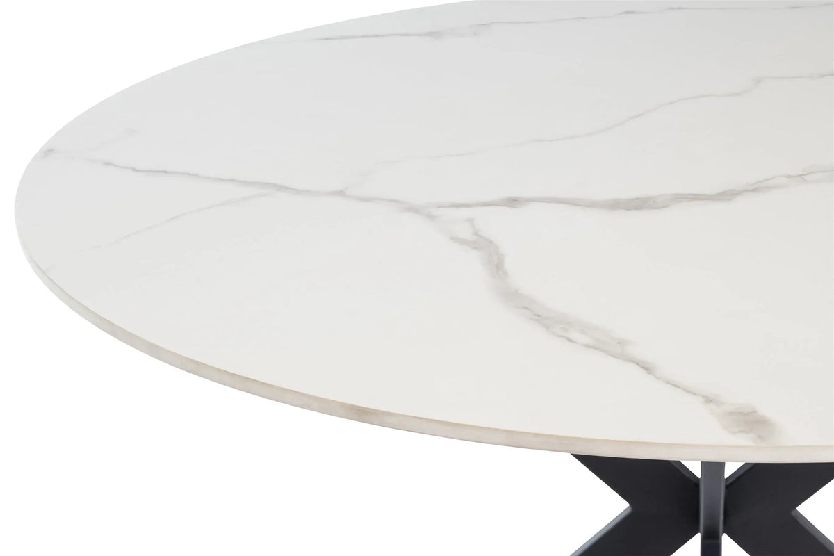 Round ceramic dining table with white marble effect top, close up of surface and edge