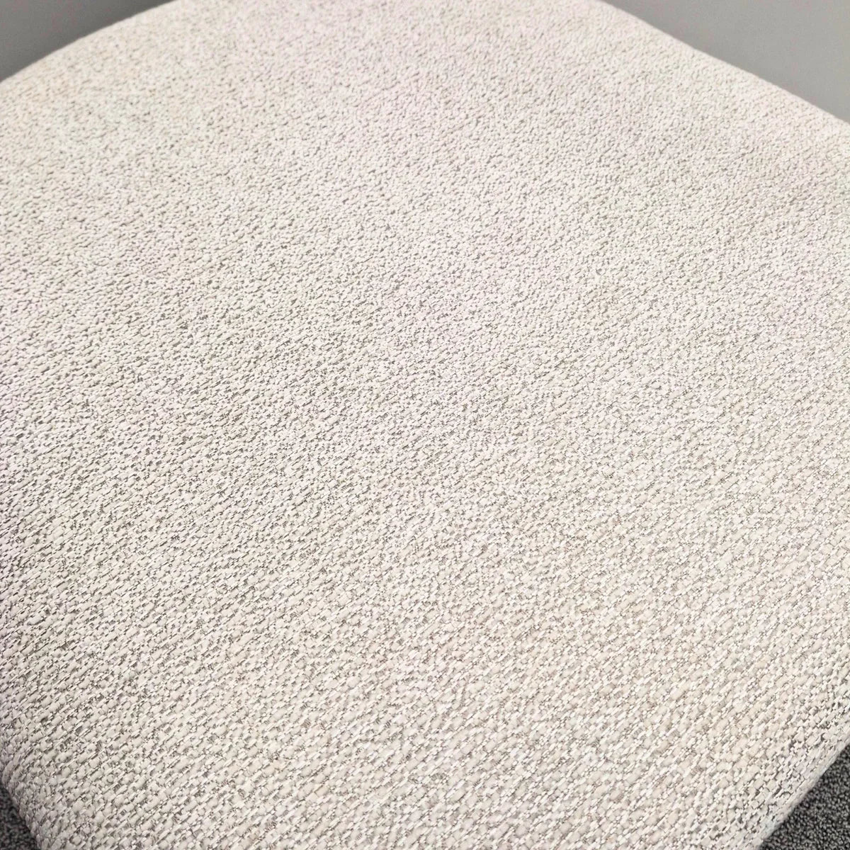 Closeup of white textured fabric seat on modern dining chair