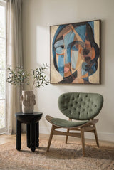 Green velvet chair featuring a tufted design, complemented by a grey elm wood frame.