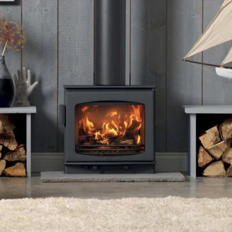 Black wood-burning stove with visible flames in panelled room