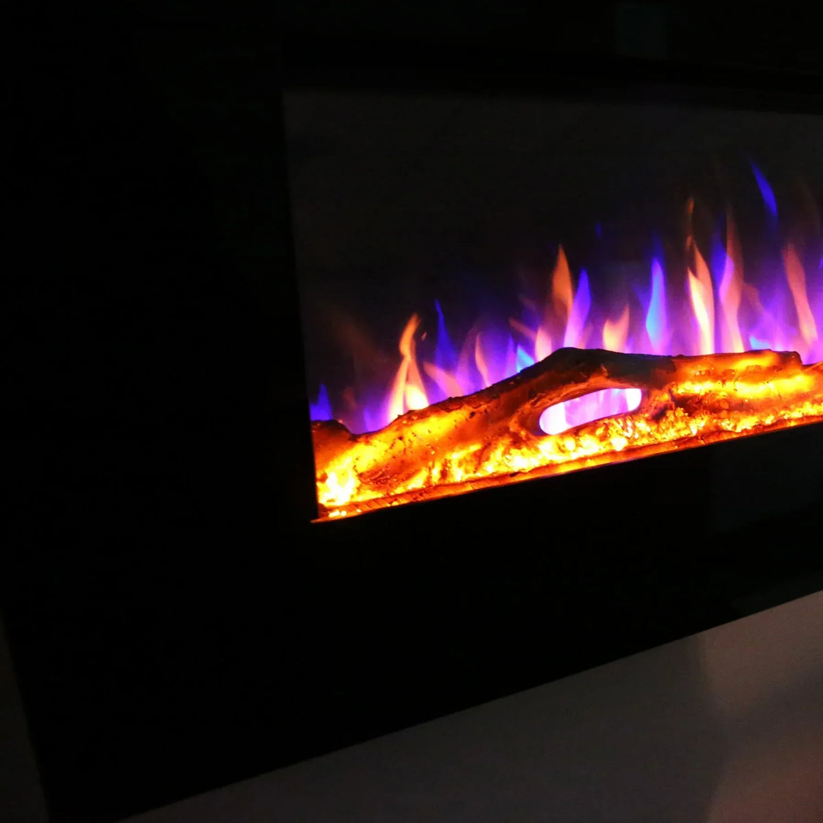Electric fireplace closeup with glowing log and orange blue flame effect